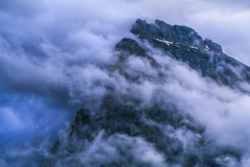 a photograph of mount oberlin in the clouds in glacier national park montana