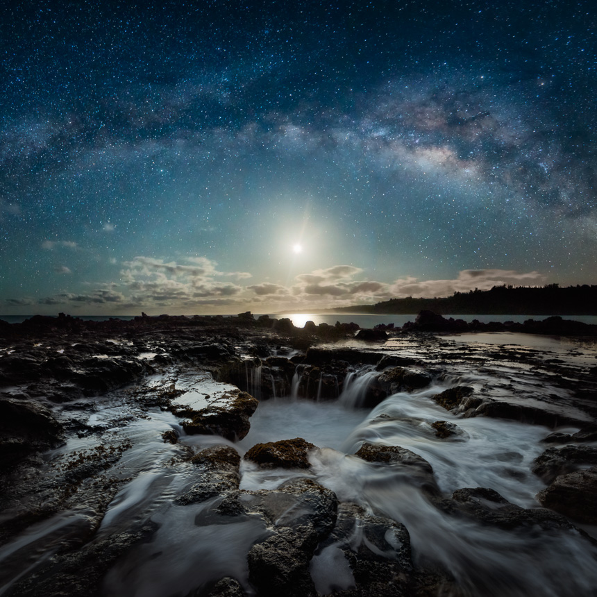 Night photography of the milky way galaxy, moon, and lava tube draining water.